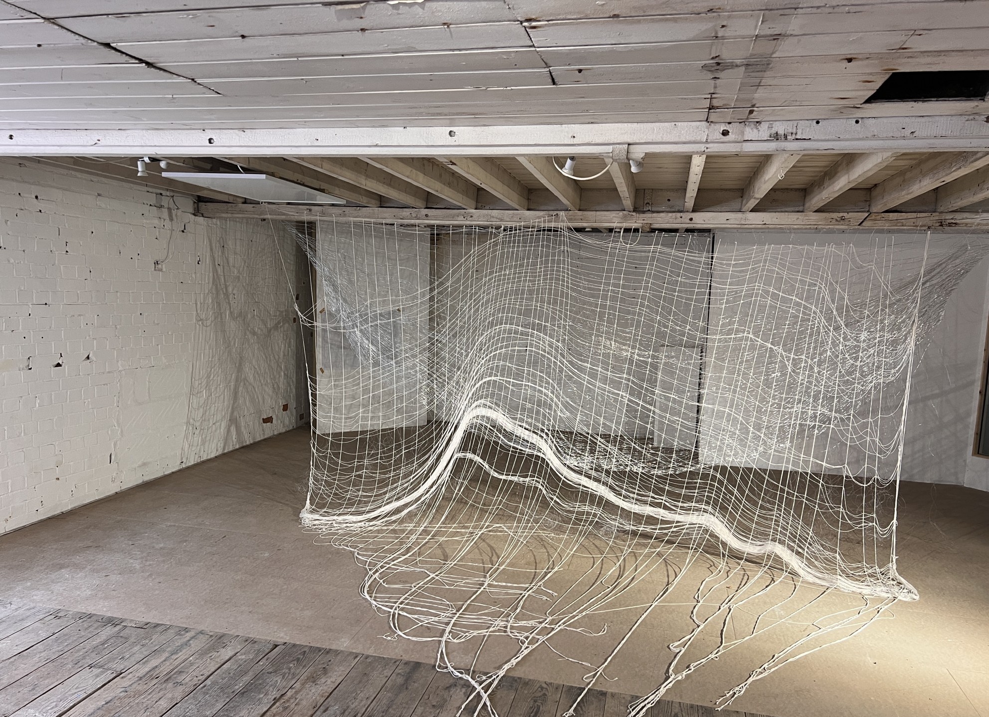 old tannery layers of woven nets hanging from the ceiling cascading to the floor creating shadows